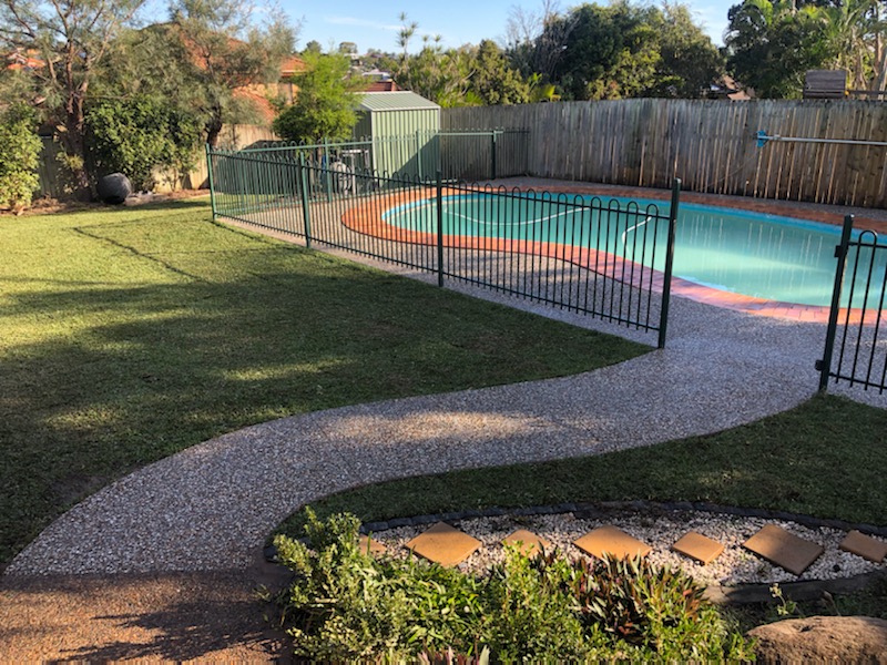 After - Exposed concrete pool surrounds with path leading to the pool area